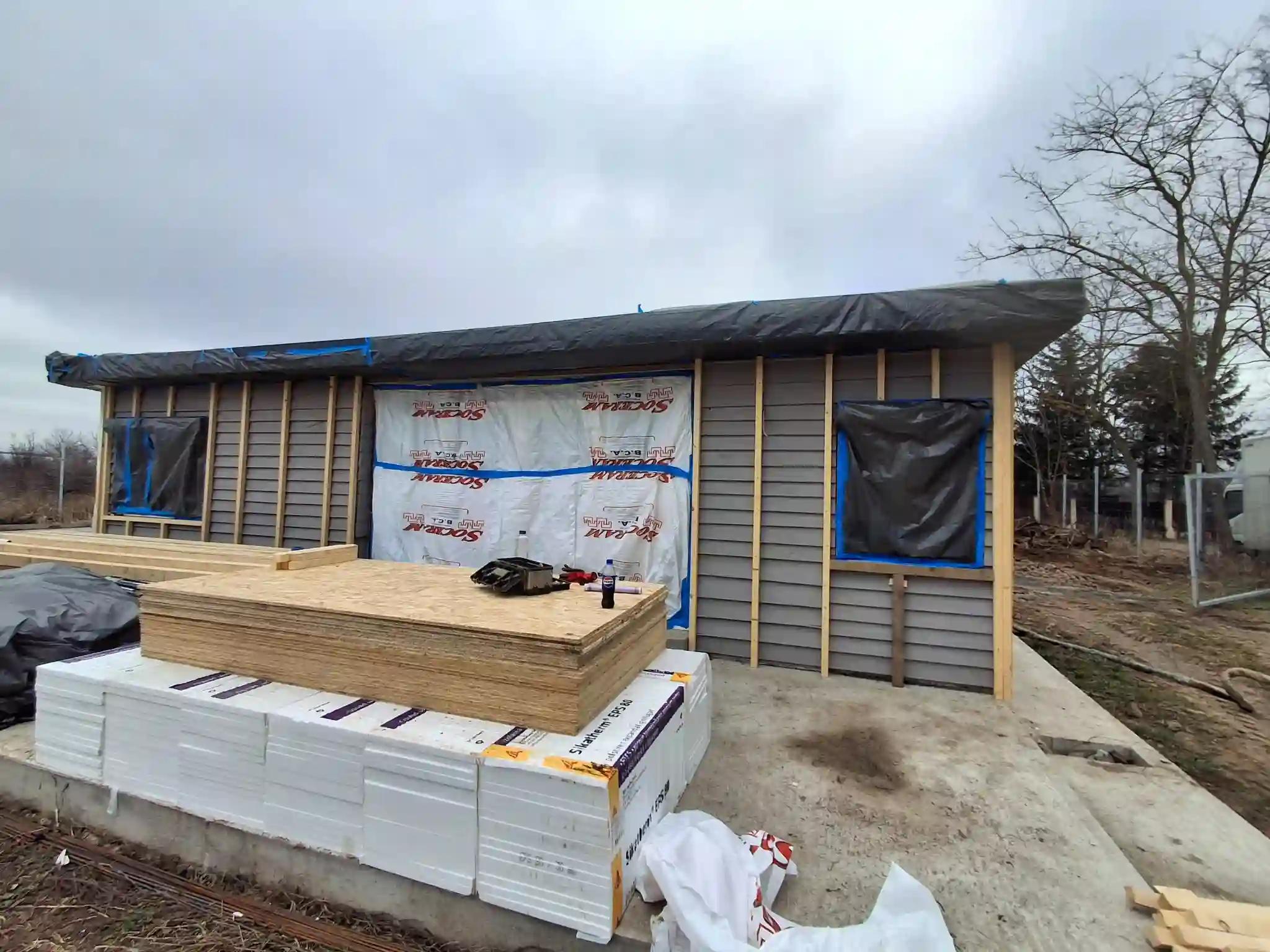 Casă din lemn în Chiajna Ilfov pregătită pentru izolație cu spumă poliuretanică, structură exterioară și materiale pe șantier