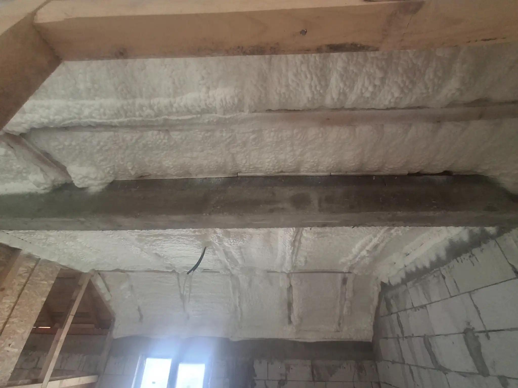 detaliu aplicare spumă poliuretanică pe suprafață neregulată pentru eficiență energetică