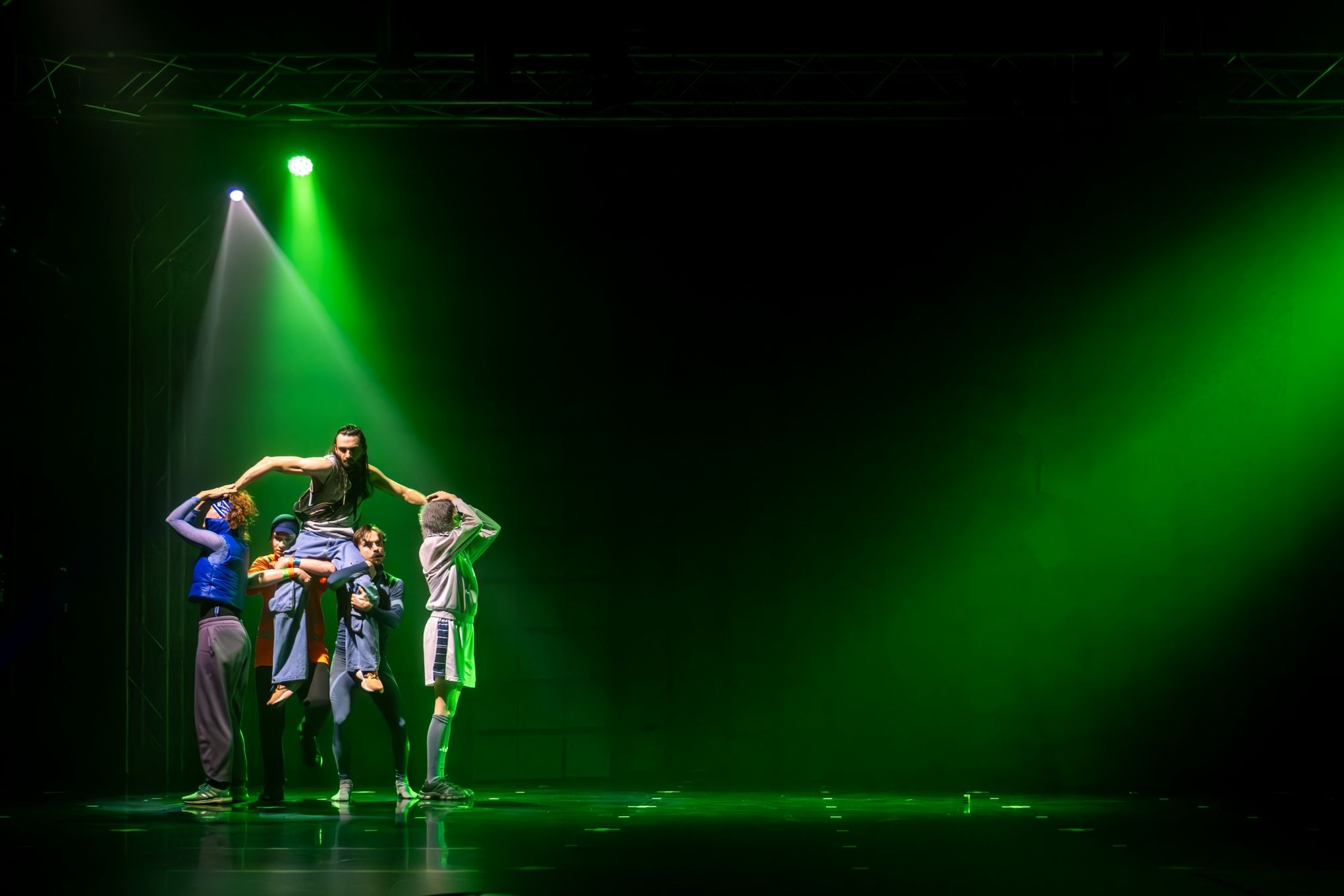 czterech aktorów wznoszących piątego aktora na scenie