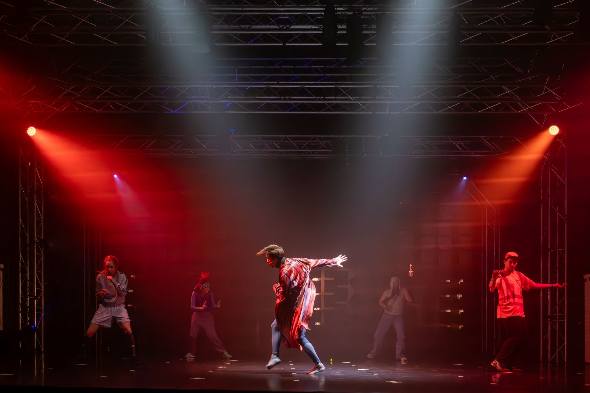 aktorzy pozujący na scenie w świetle reflektorów