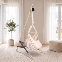 Lullaby Federwiege in Naturbeige mit Motor am Holzständer in einem hellen Wohnzimmer (Mit KI bearbeitetes Bild)
