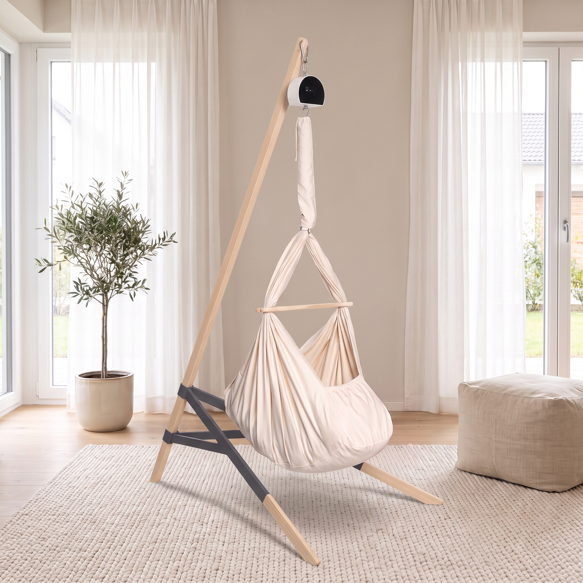 Lullaby Federwiege in Naturbeige mit Motor am Holzständer in einem hellen Wohnzimmer (Mit KI bearbeitetes Bild)
