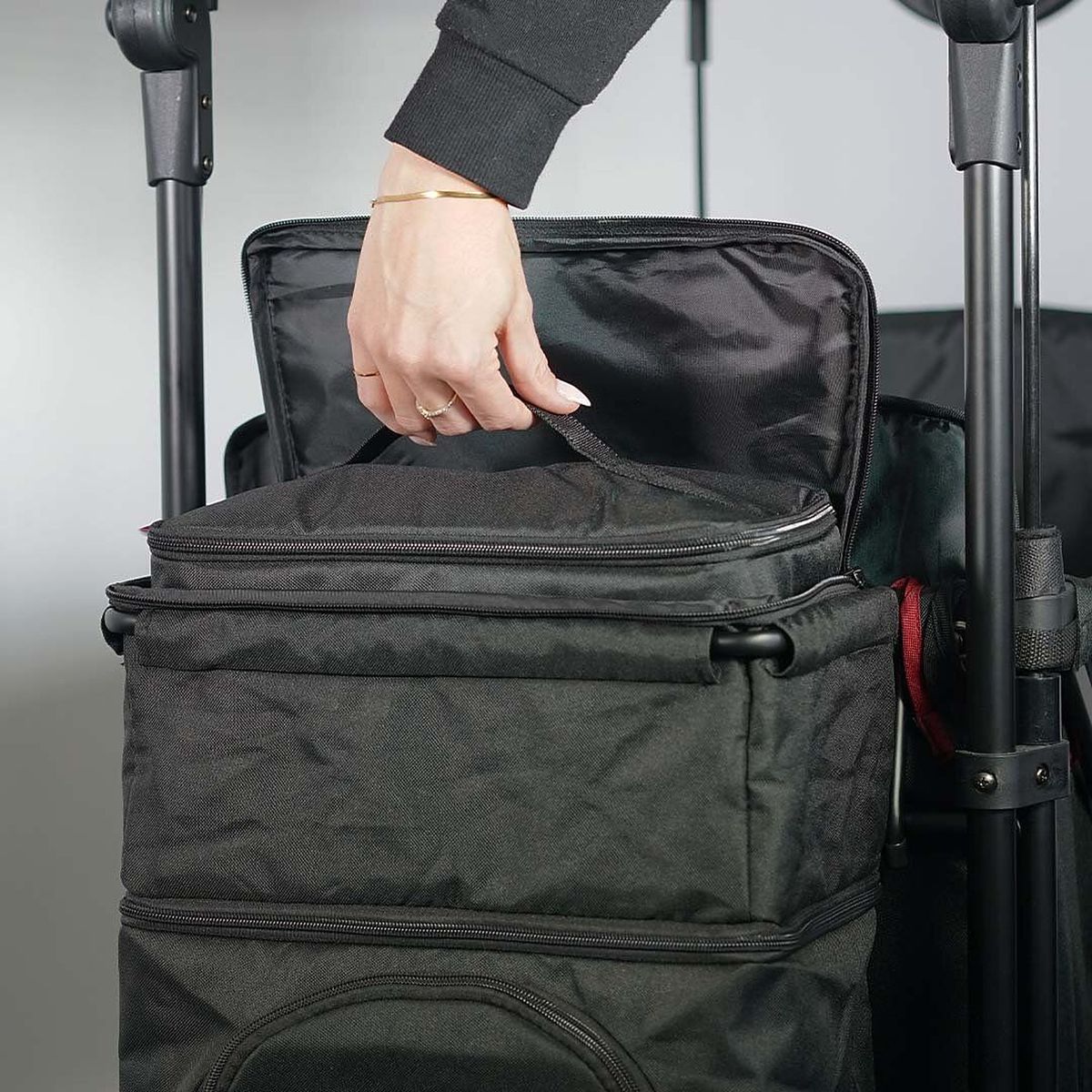 Hand hebt die schwarze Kühltasche am Griff aus der Hecktasche des SmartCruiser