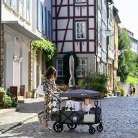 WagonPro City in Indigoblau mit Dach in einer Altstadtgasse, eine Frau mit Einkaufstüten zieht ein Kind