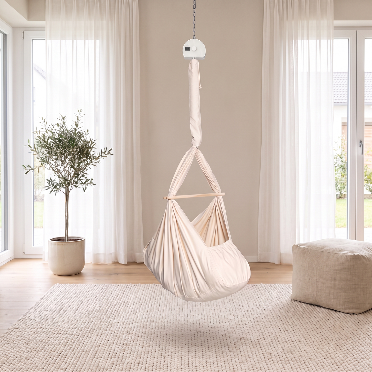 Lullaby Federwiege in Naturbeige mit Motor an der Decke in einem hellen Wohnzimmer mit Teppich und Olivenbaum (Mit KI bearbeitetes Bild)