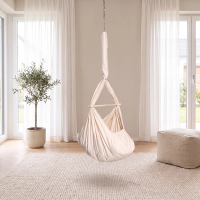 Naturbeige Lullaby Federwiege ohne Motor an Kette und Feder an der Zimmerdecke in einem hellen Wohnzimmer (Mit KI bearbeitetes Bild)