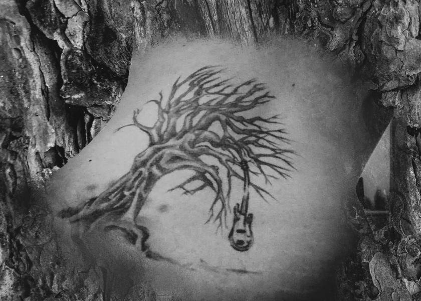 blended image of tree bark with tree back tattoo