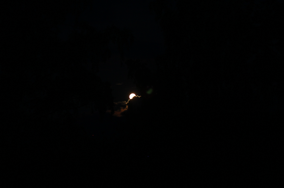 the moon behind clouds