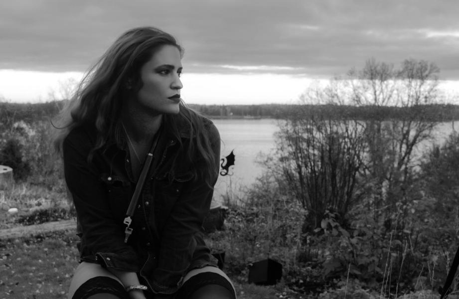 woman on chair outside, lake in background