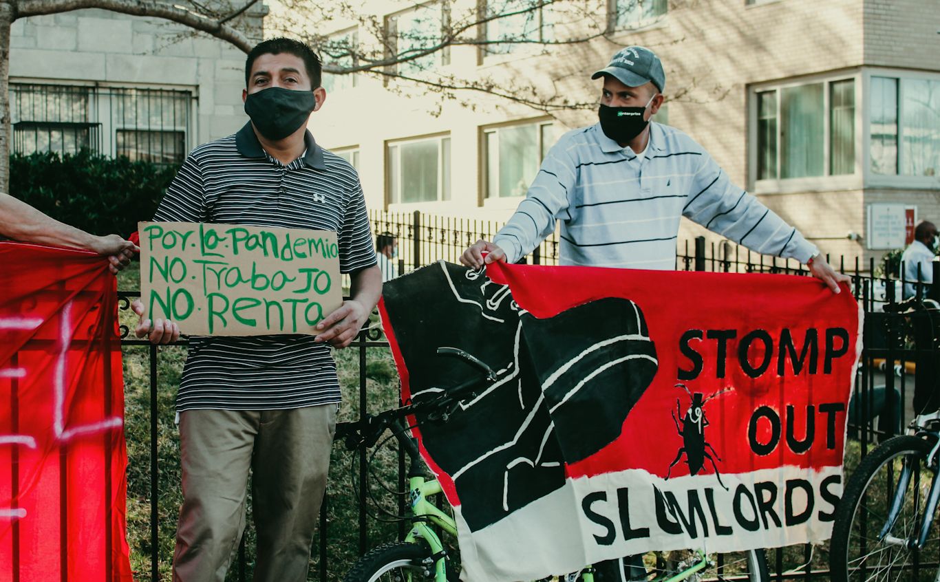 Tenants and supporters hold signs facing the street. One on the left reads, ‘because of the pandemic, no food, no rent.’ Eleanor Goldfield | ArtKillingApathy.com