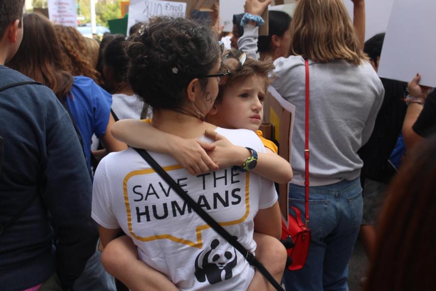 mother holding her child wearing save the humans shirt