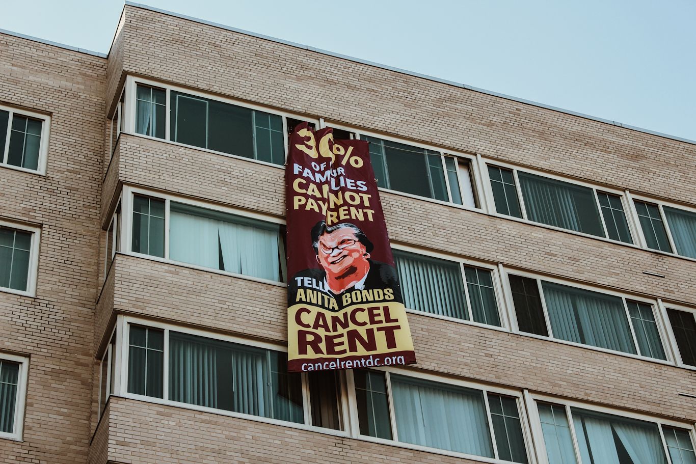 A banner with a message to DC Councilmember Anita Bonds reading: ‘30% of our families cannot pay rent.’ Eleanor Goldfield | ArtKillingApathy.com