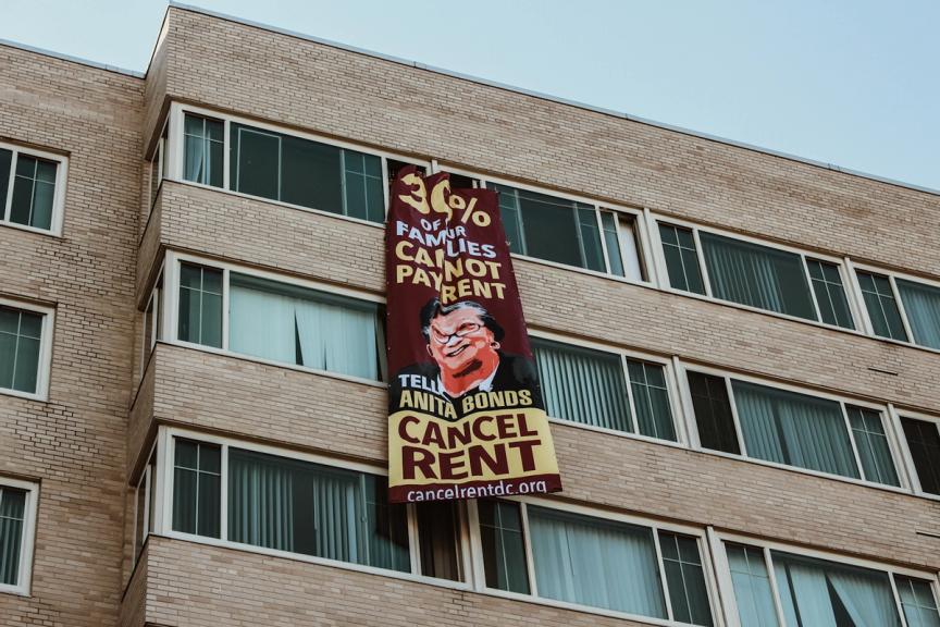 A banner with a message to DC Councilmember Anita Bonds reading: ‘30% of our families cannot pay rent.’ Eleanor Goldfield | ArtKillingApathy.com