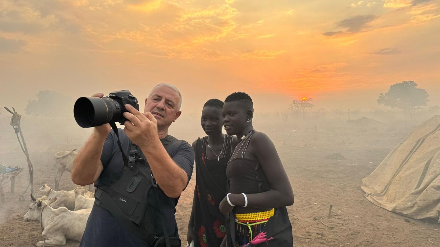 Robertino Radovix mostra l'anteprima di uno scatto a due donne Mundari in un accampamento al tramonto, Sud Sudan.