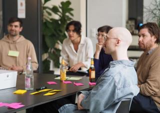 People sitting around a table with post-its during a workshop