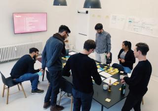 Group of people standing around a conference table during a workshop