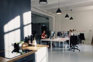 Two people sitting at a shared desk in a sunny office