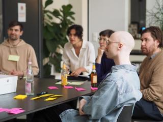 People sitting around a table with post-its in a workshop setting