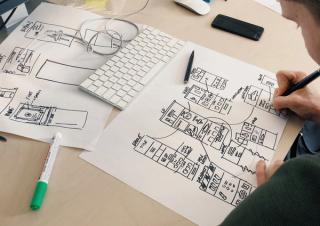 A person drawing wireframes on a piece of paper