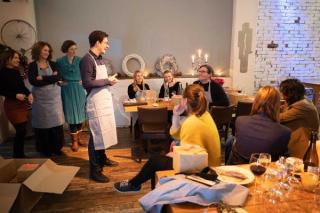 Person talking to a group of people in a team cooking event setting