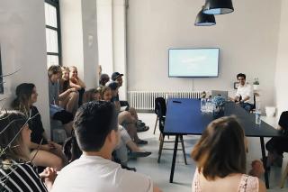 Student group sitting in front of a screen in an office