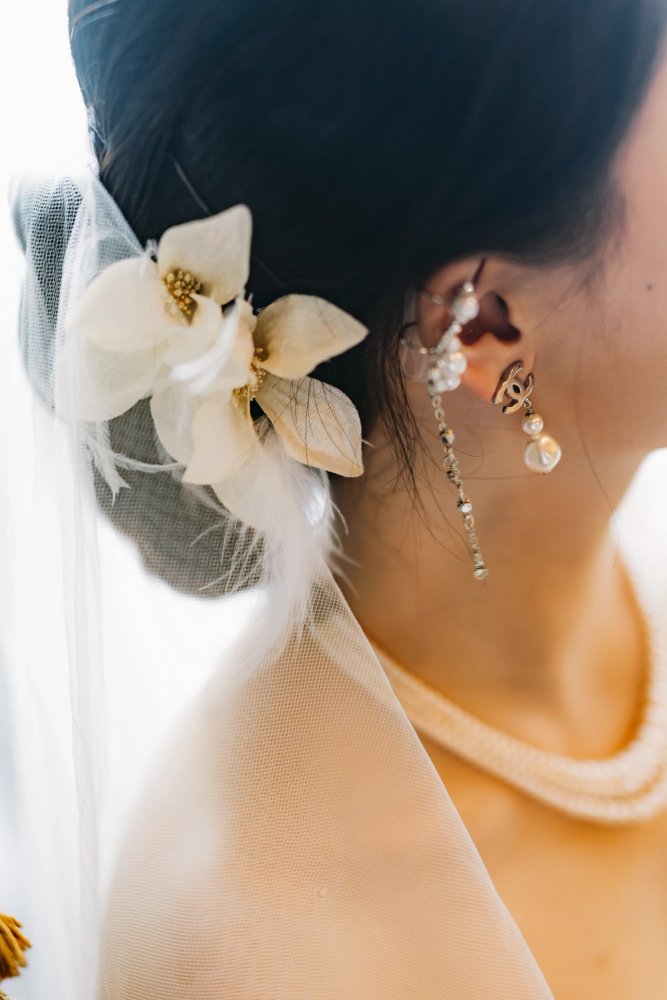 Close-up of the bride's white floral hair accessory, veil and pearl drop earring at Casa Loma.