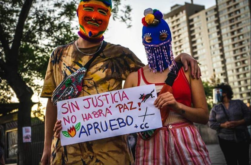 kvinne holder opp en plakat i en demonstrasjon i Chile