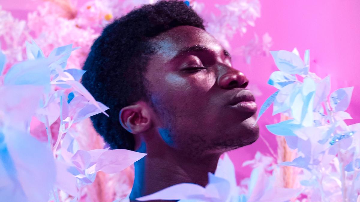 Mann blant rosa blomster. Illustrasjonsbilde tatt av Brian Asare fra Unsplash