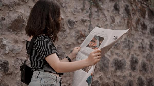 Illustrasjonsbilde av en kvinne som leser avisen tatt av Ekrulila fra Unsplash
