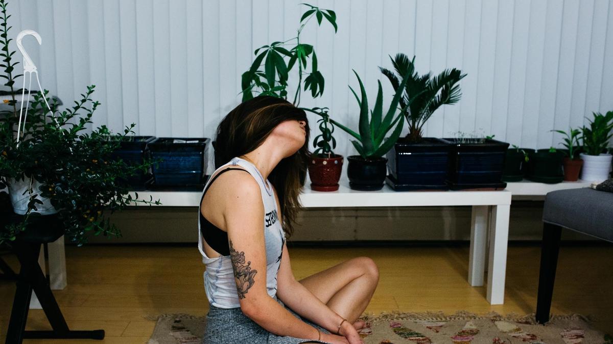 Kvinne sitter på gulvet i leiligheten sin