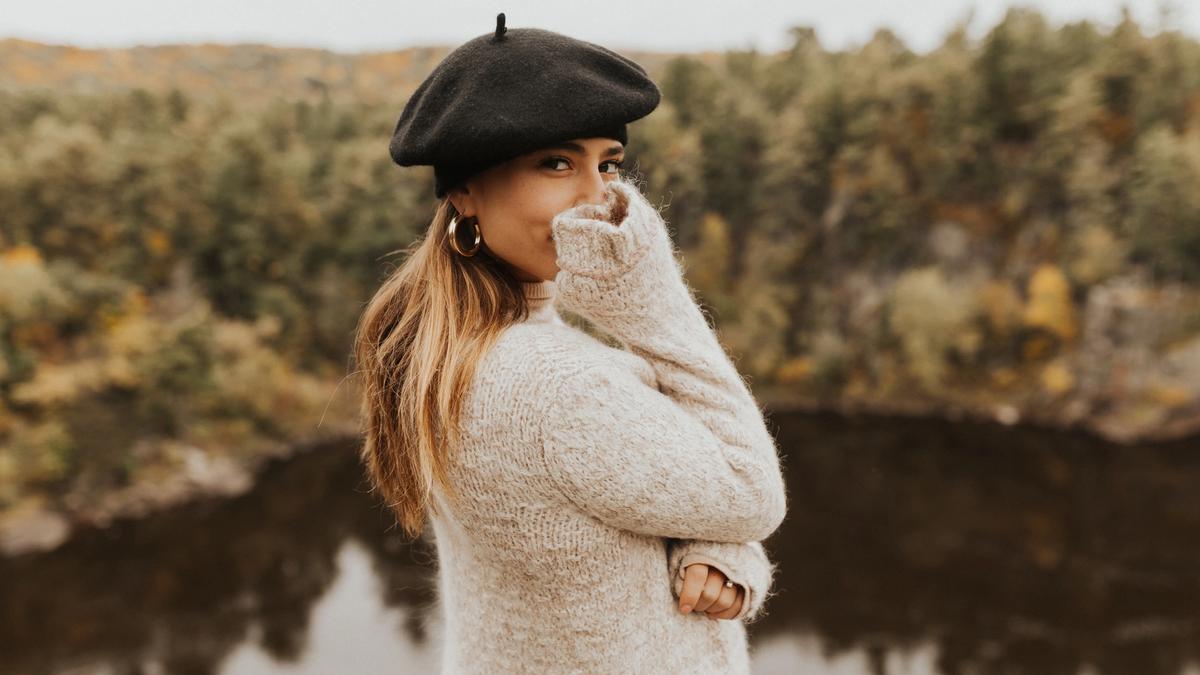 Ung kvinne i skogen med en liten lue