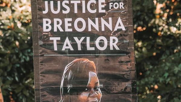 Noen som holder plakat med skriften: "Justice for Breonna Tyler"