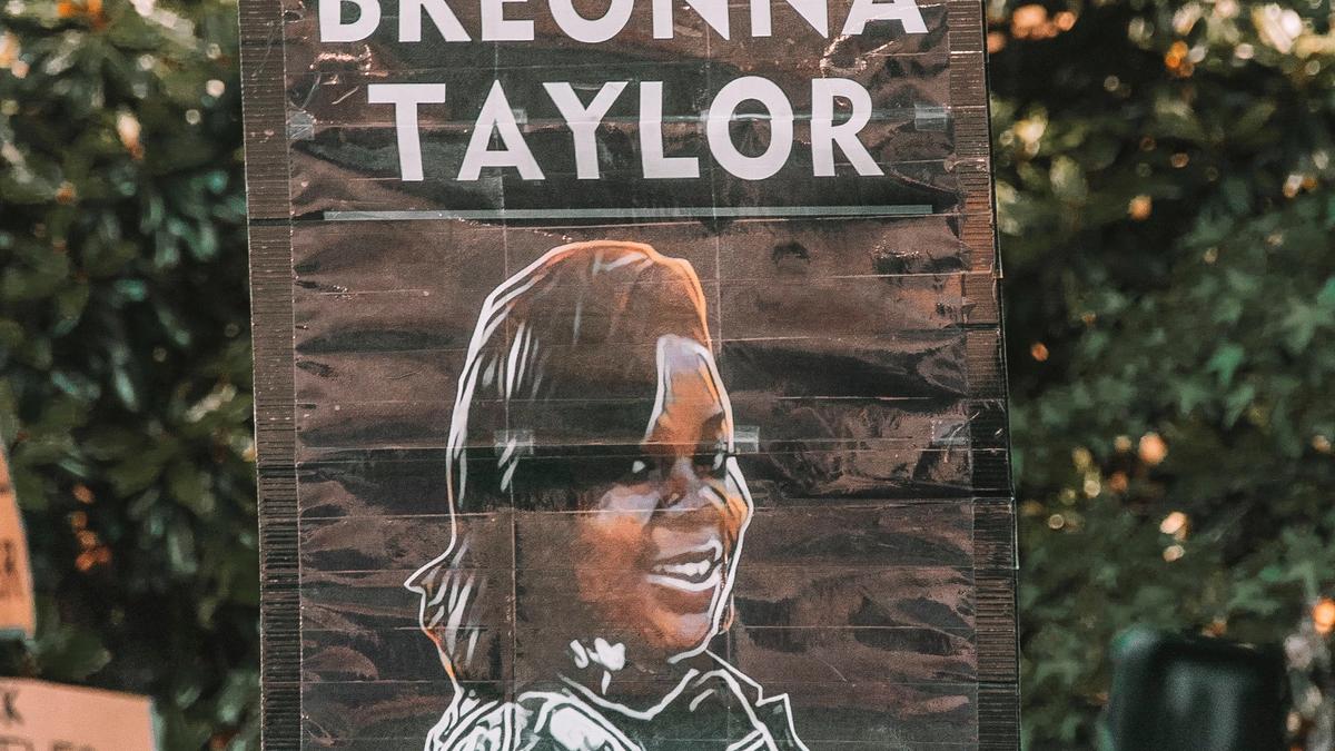 Noen som holder plakat med skriften: "Justice for Breonna Tyler"