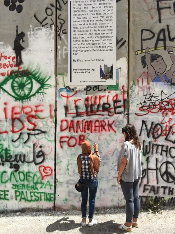 Bilde av to kvinner som står foran en vegg med graffiti (Foto privat)