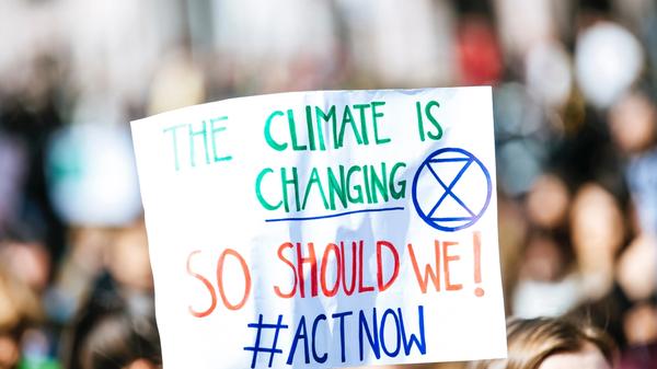 Plakat i en demonstrasjon med følgende slagord: "The Climate is Changing - So should we! #ACTNOW. Illustrasjonsbilde tatt av Markus Spiske fra Unsplash