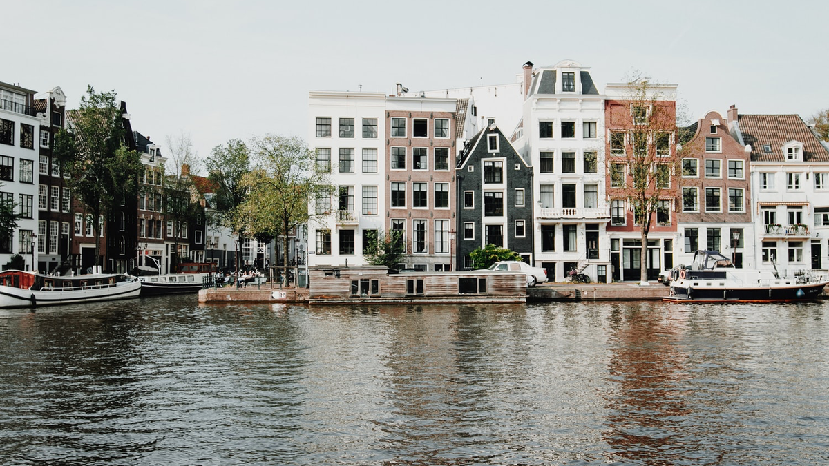 Bilde av Amsterdams karakteristiske murbygg, med kanalen i front.