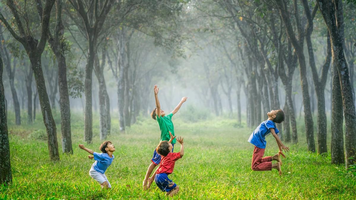 Illustrasjonsbilde av glade barn som leker i skogen tatt av Robert Collins fra Unsplash
