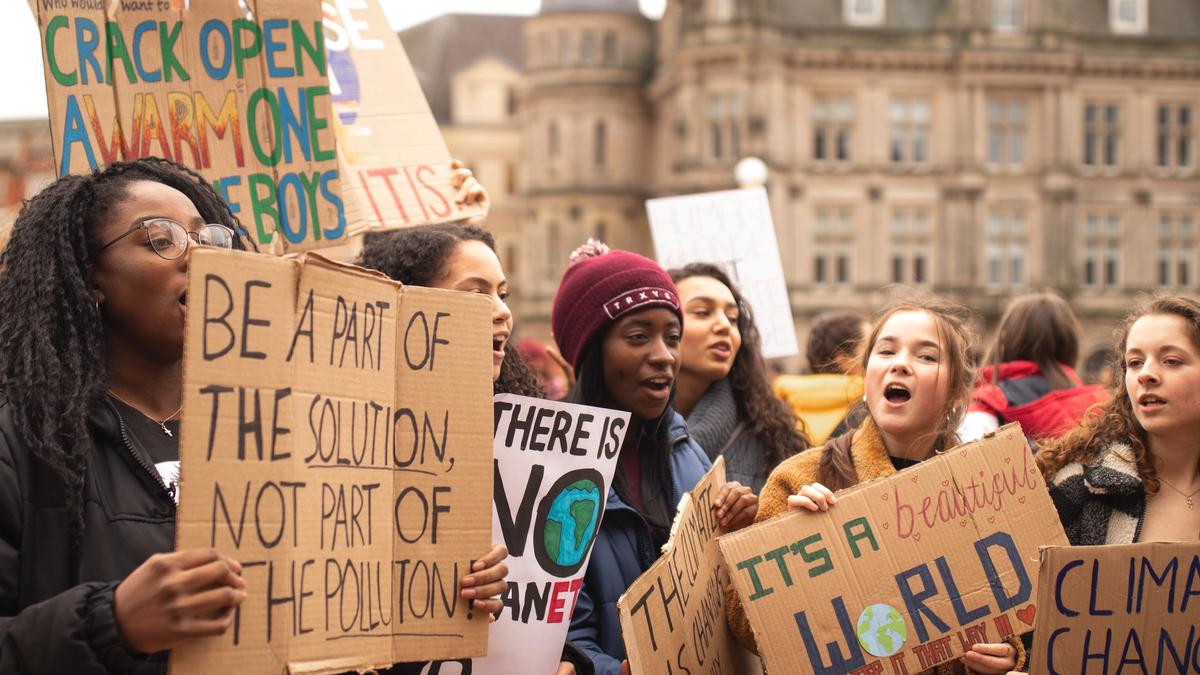Illustrasjonsbilde av ungdommer som demonstrerer med plakater hvor det blant annet står "be part of the solution, not part of the pollution, tatt av Callum Shaw fra Unsplash