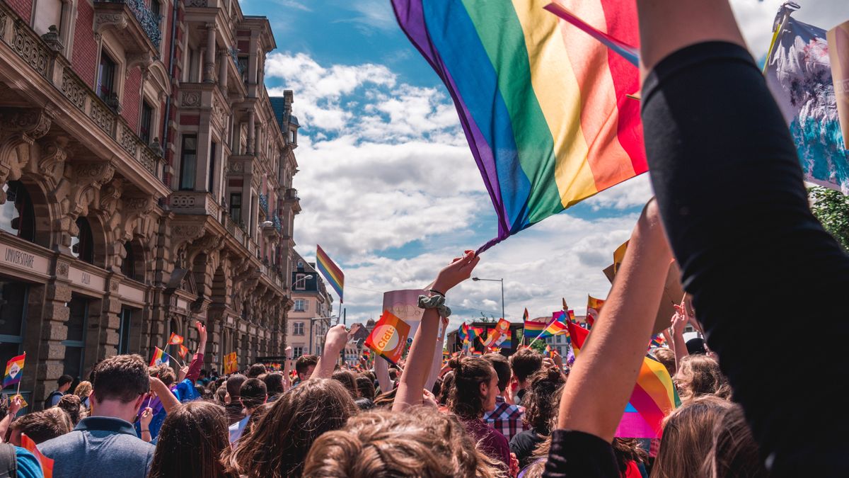 Mange mennesker som flagger med Pride-flagg