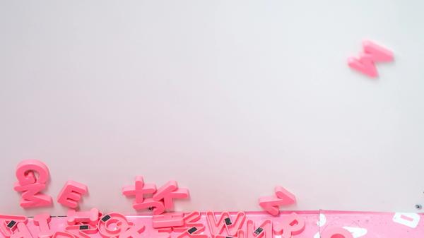 Rosa og hvite bokstaver som ligger rotete til på et hvit golv langs en hvit vegg. Illustrasjonsbilde tatt av Jason Leung fra Unsplash