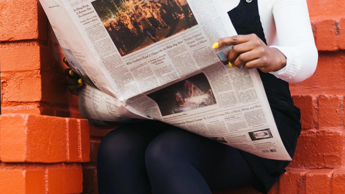 Illustrasjonsbilde av en kvinne som leser avisen tatt av The Creative Exchange fra Unsplash