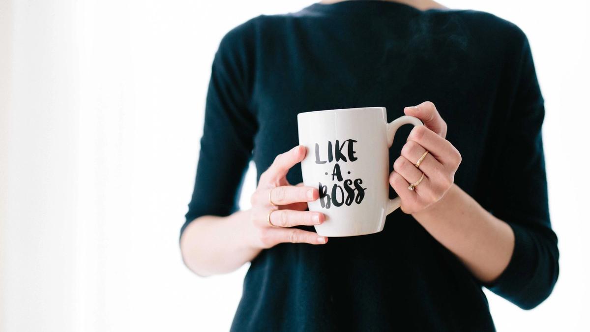 En kvinne holder et krus som sier "like a boss"