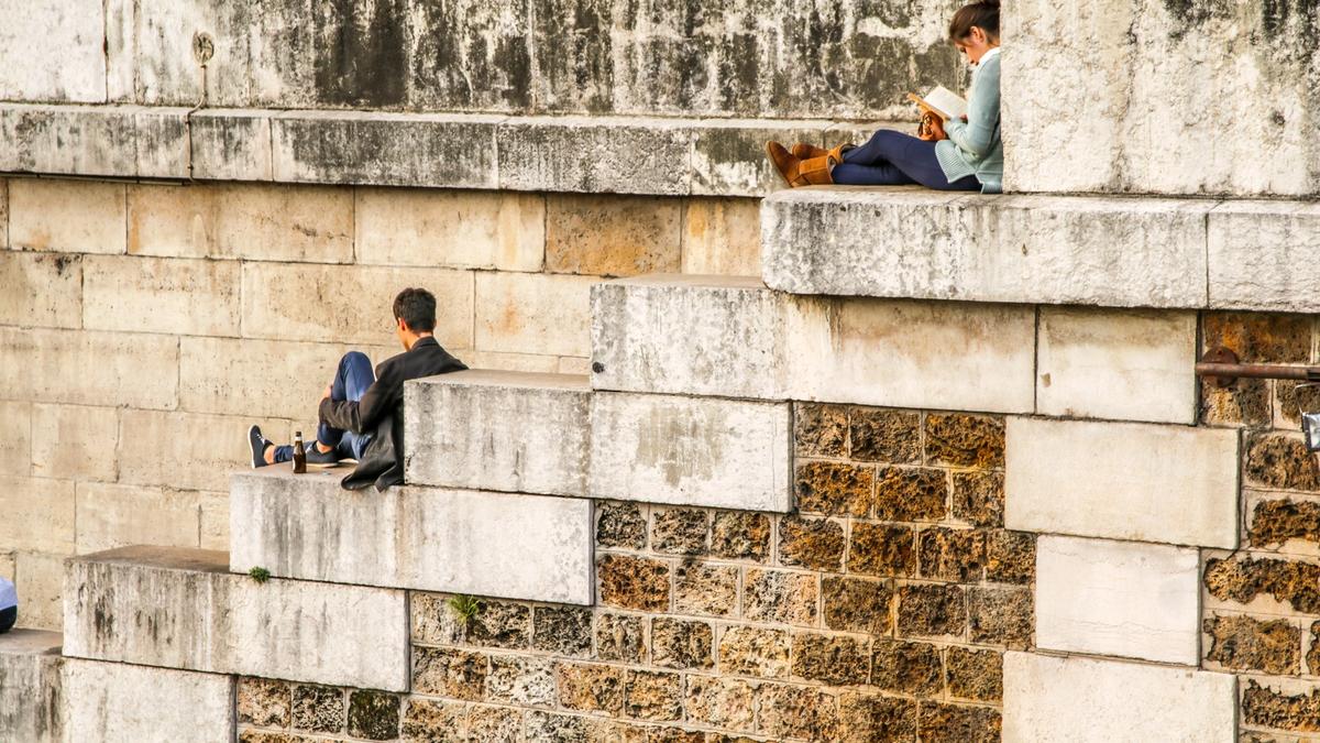 To sitter og leser avisen i Paris