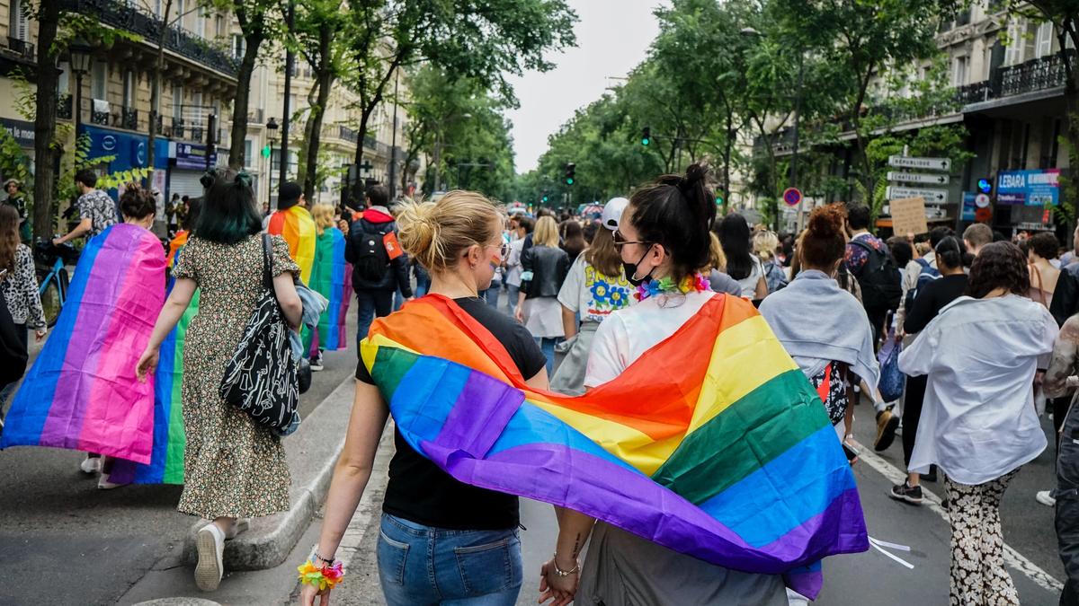 To personer som har et stort regnbue-flagg på ryggen