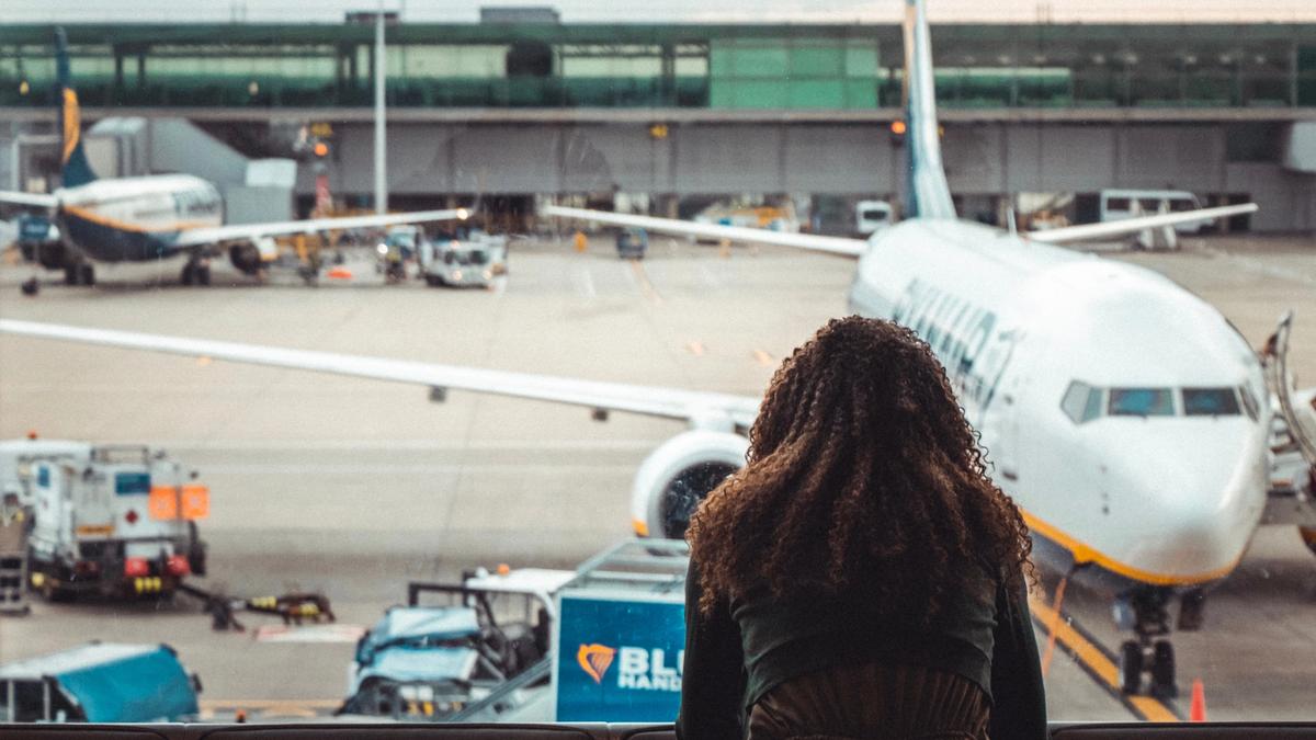 Kvinne sitter på gate på en flyplass