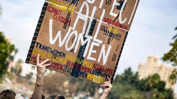 Kvinne holder ett skilt som sier "respect all women" i en demonstrasjon