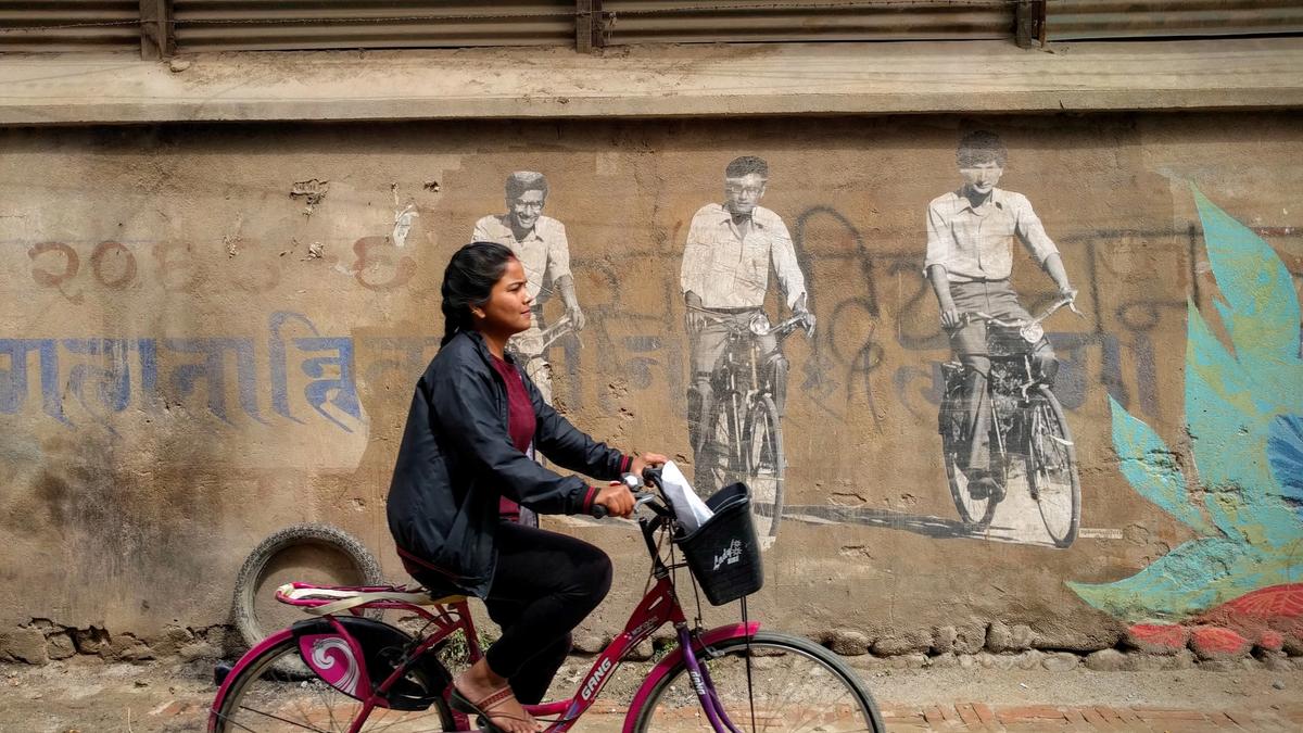 En nepalsk jenter sykler i en gate