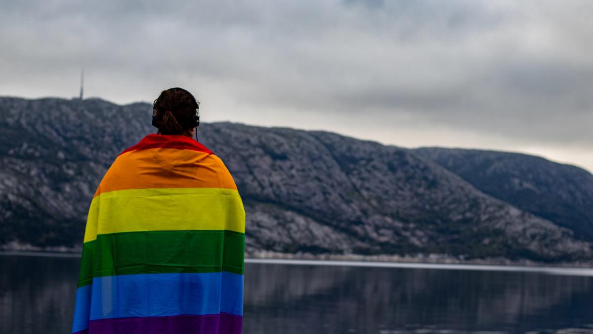 Kvinne med regnbueflagg over skuldrene. Bilde tatt av Karoline Skarstein