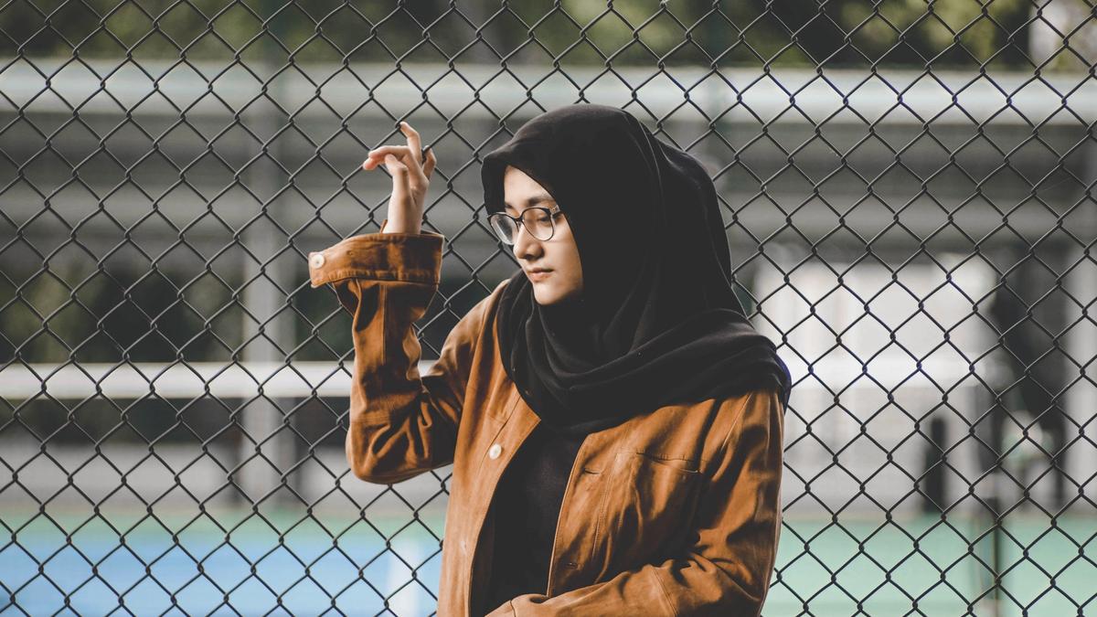Jente med svart hijab og brun jakke