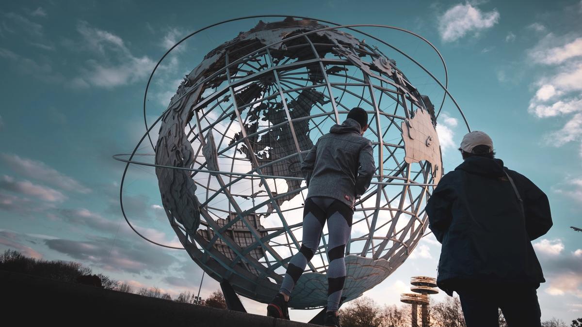 Illustrasjonsbilde av en jordklode og to personer som ser på den, tatt av Patrick Robert Doyle fra Unsplash